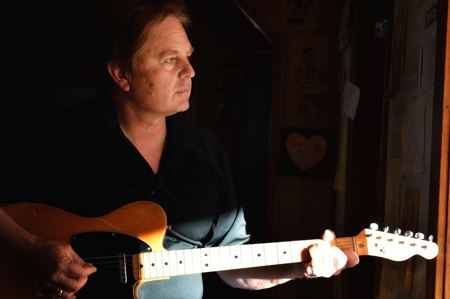 Dino Cornay plays guitar at home in Folsom, NM