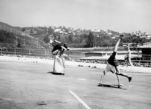 Tim Keller skateboarding atop trash can in contest, 1966