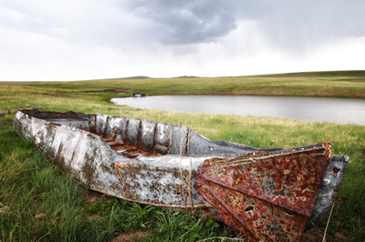 Rusted boat at Johnson Mesa stock pond in New Mexico
