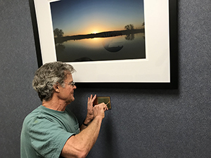 Tim Keller installing "Oasis State Park at Sunrise" at Roosevelt General Hospital, Portales, 2018