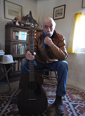 Archie West in living room on Turquoise Trail with Martin 0015 guitar